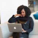woman in black coat using MacBook